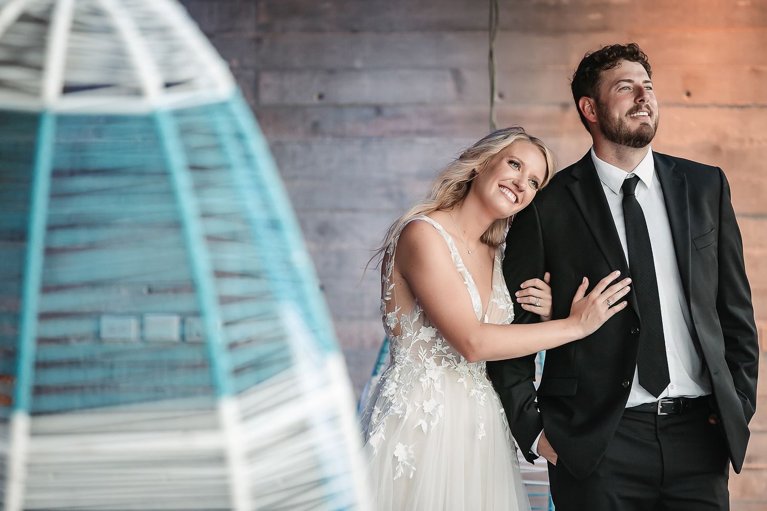 Couple shares a romantic moment in an industrial-style venue with blue-tinted lighting.