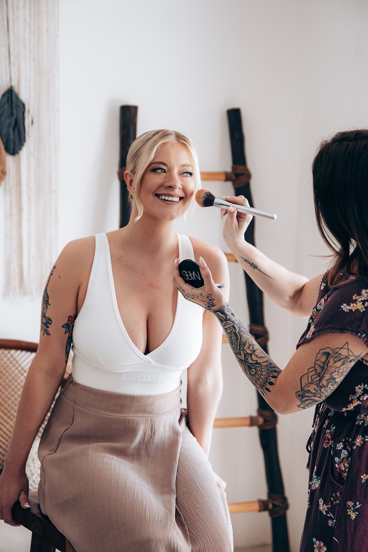 Wedding preparation scene with makeup application in bright room.