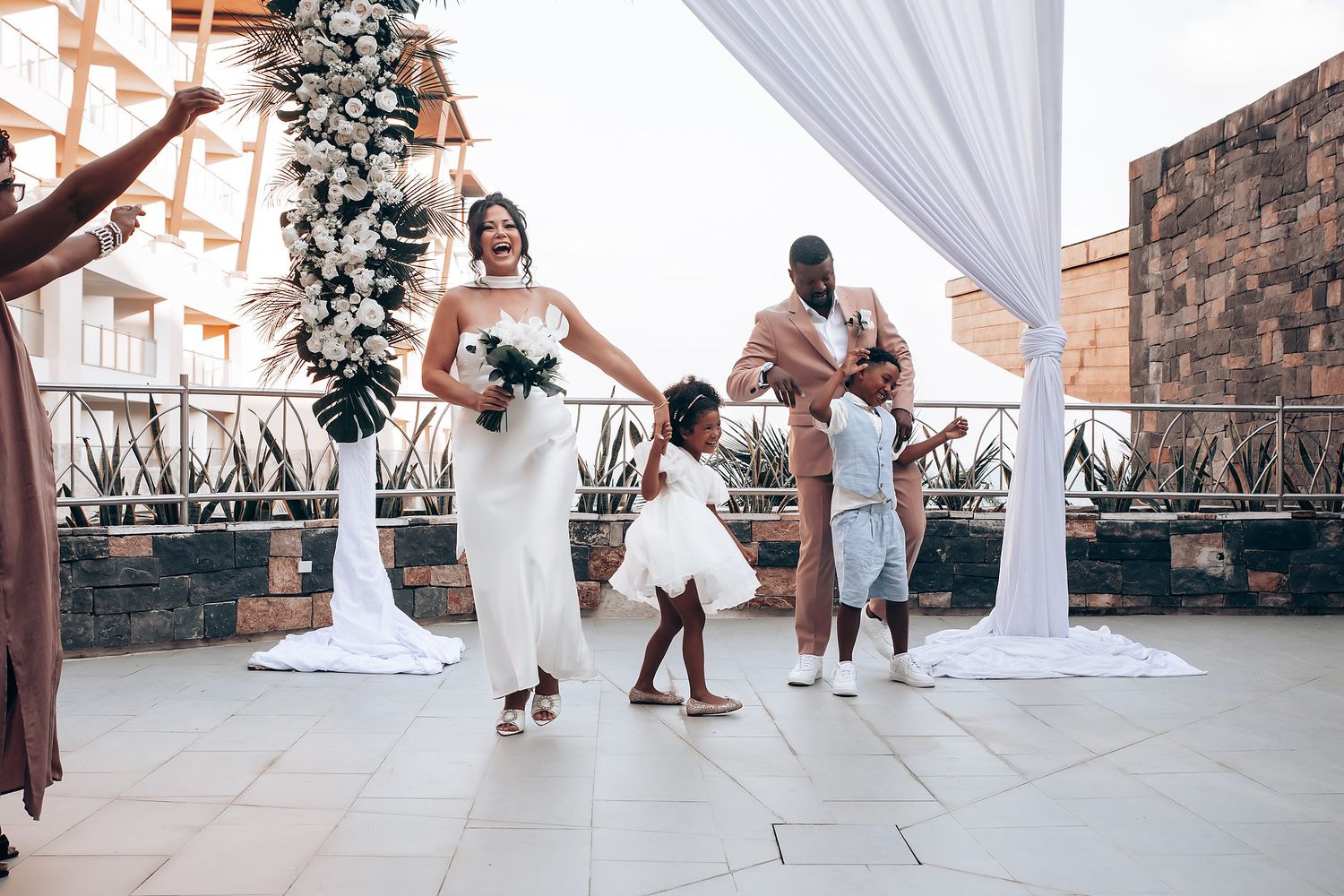 Wedding celebration under white draped canopy with dancing and festivities.