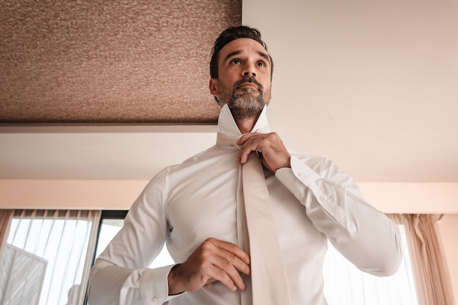 Side profile of person in white shirt against neutral background.