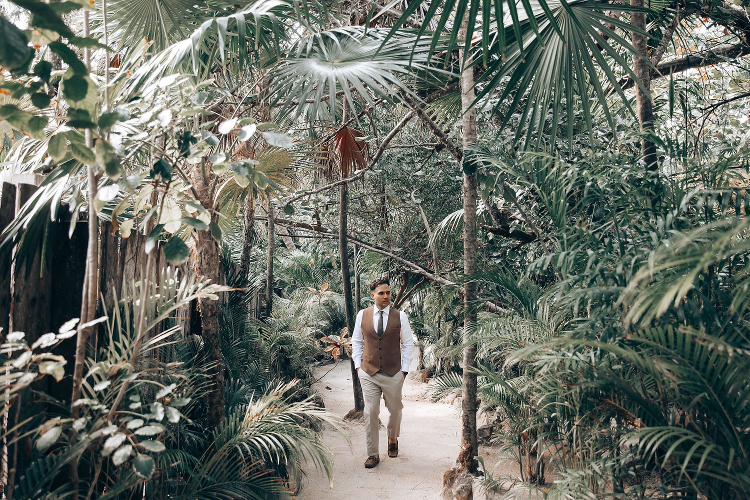 Lush tropical greenhouse setting with palm trees and greenery creating a natural wedding venue atmosphere.