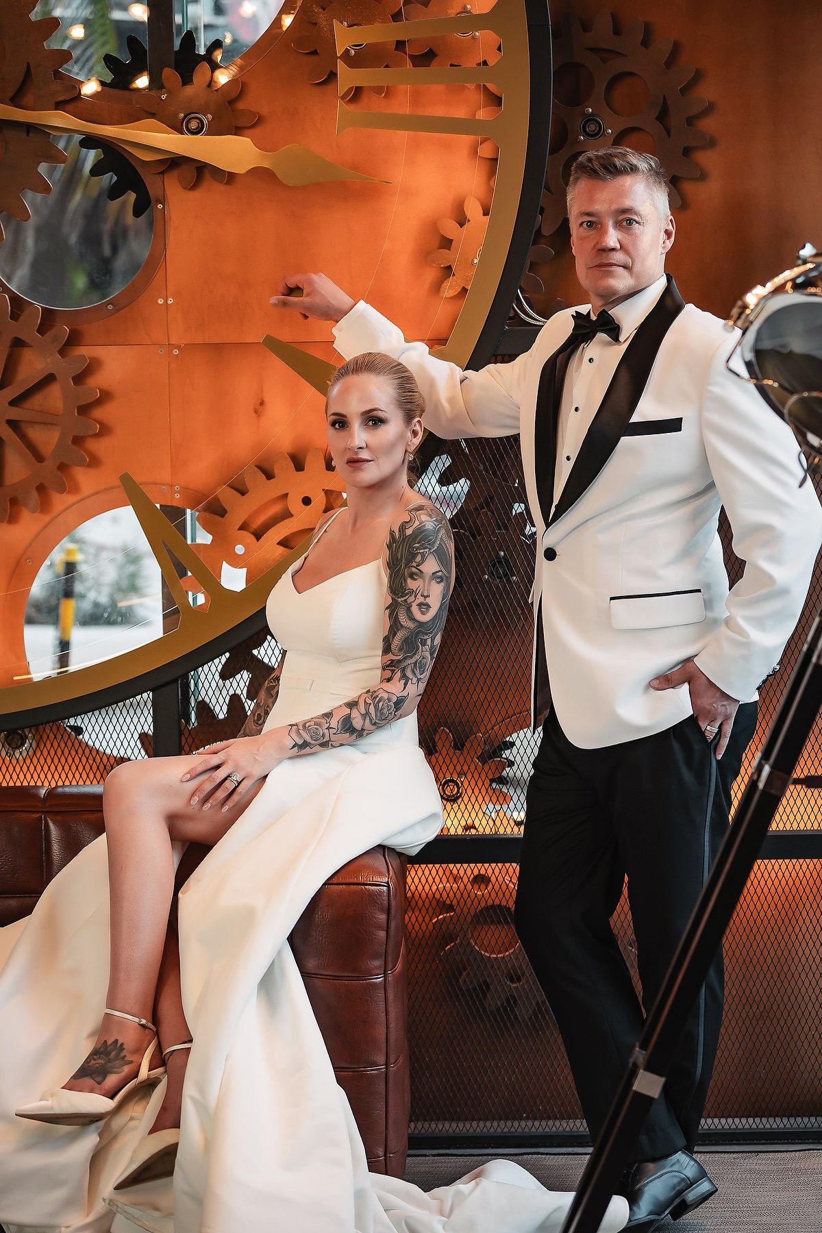 Modern industrial venue with decorative metal gears and dramatic lighting for wedding photos.
