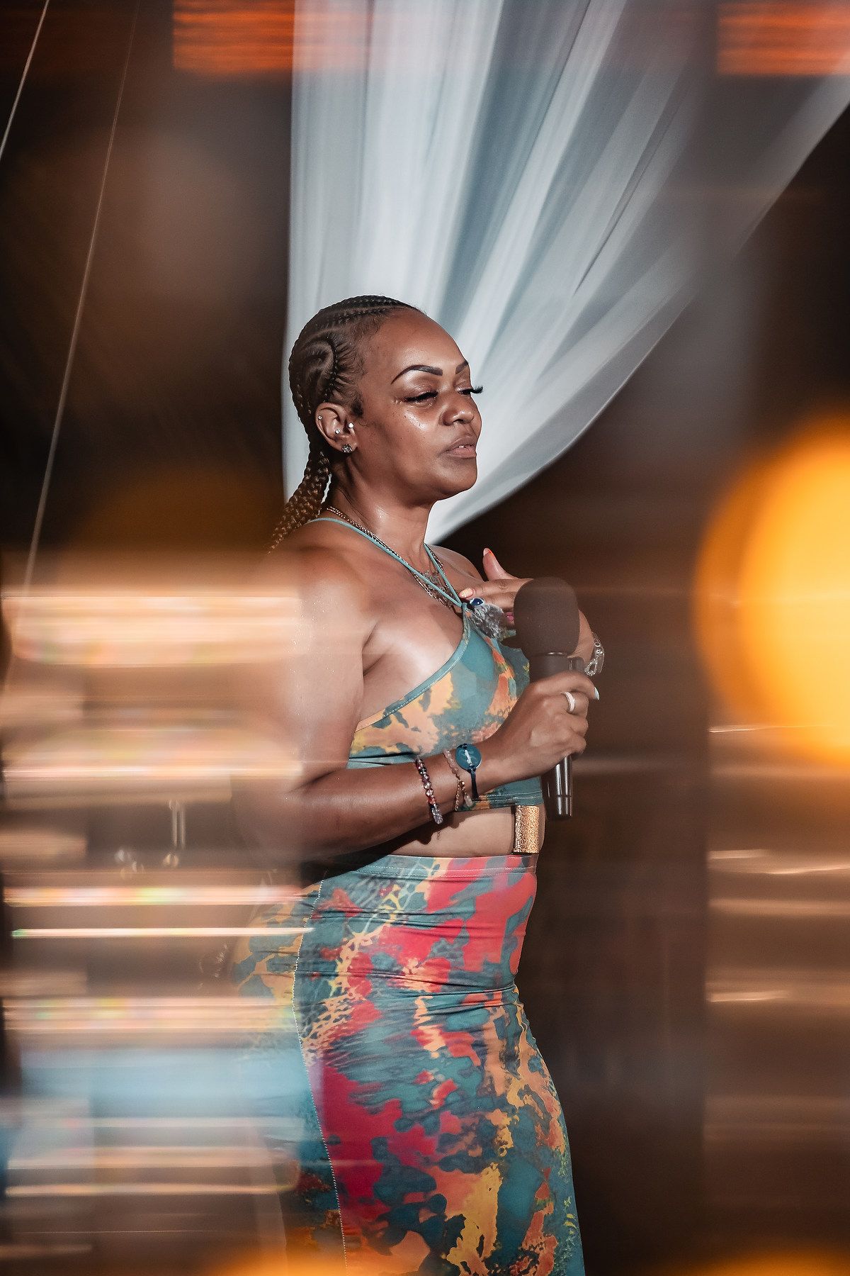 A person in a teal dress dances with motion blur effects creating an artistic performance shot.