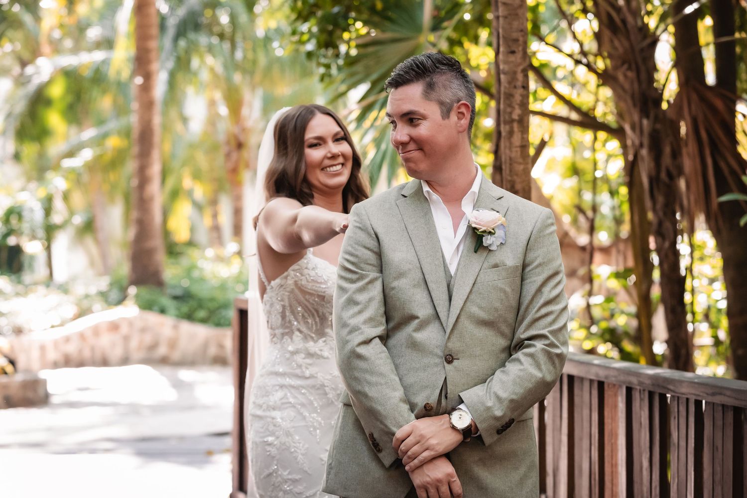 Couple shares a joyful moment on a rustic wooden walkway surrounded by greenery.