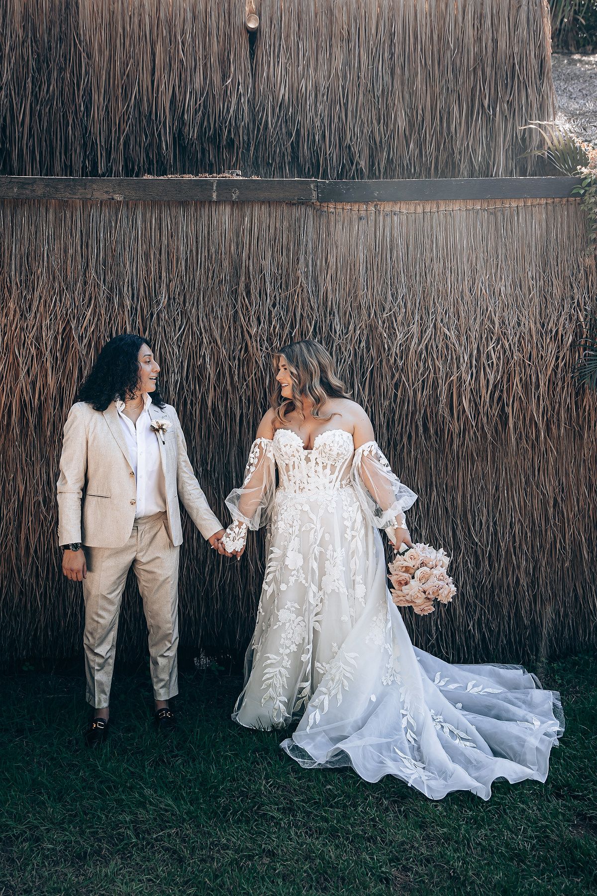 Elegant wedding portraits against a textured reed wall backdrop in natural lighting.