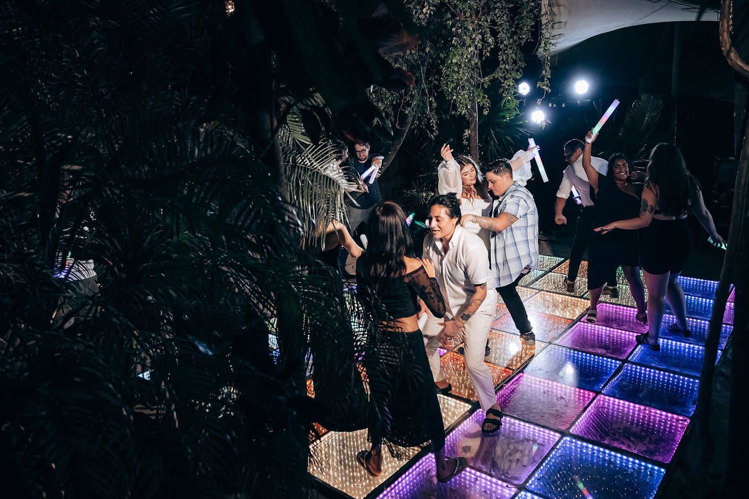 Guests enjoying themselves on a modern LED dance floor with dramatic blue lighting.
