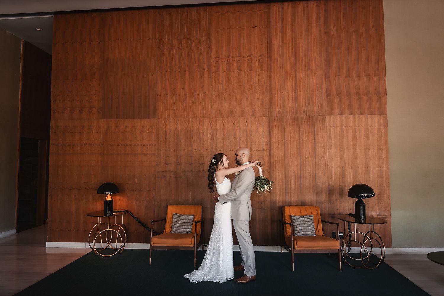 A modern wedding venue interior with wood paneling and mid-century modern furniture.