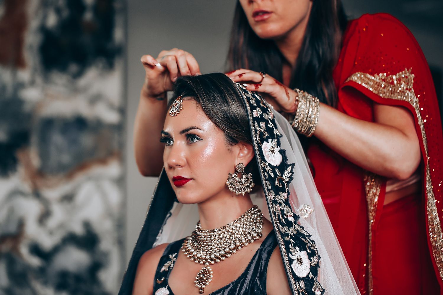 Traditional Indian bridal jewelry featuring ornate necklaces and bangles with red and black attire.
