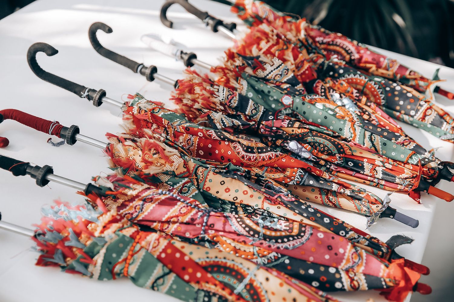 Colorful red and silver metallic decorative hooks arranged in a repeating pattern on a dark surface.