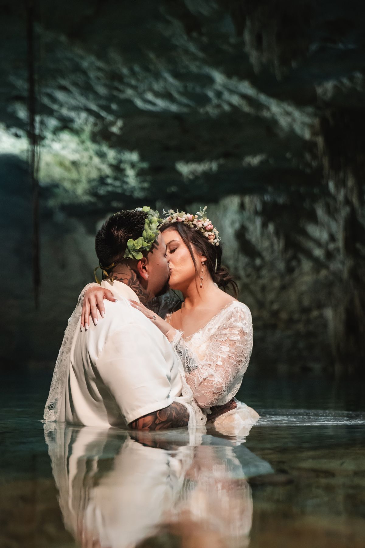 Bride and groom kiss during ceremony at Cenote Taak Bi Ha cenote