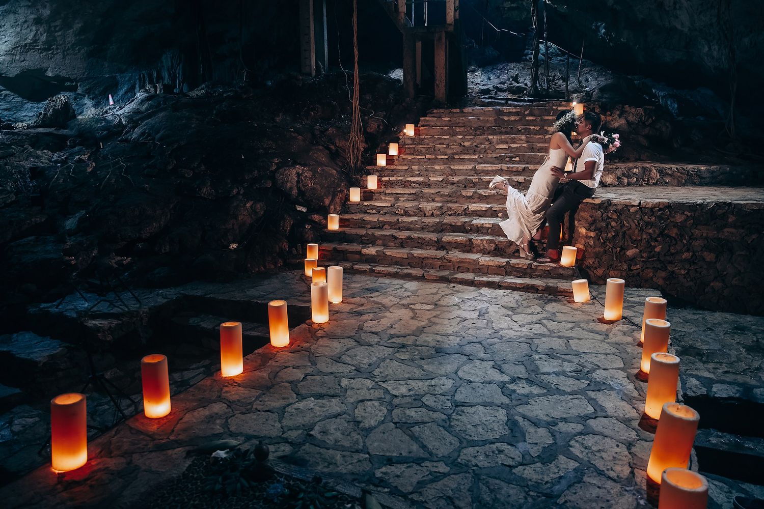 Stone pathway lined with glowing luminaries creates a romantic outdoor ambiance at dusk.