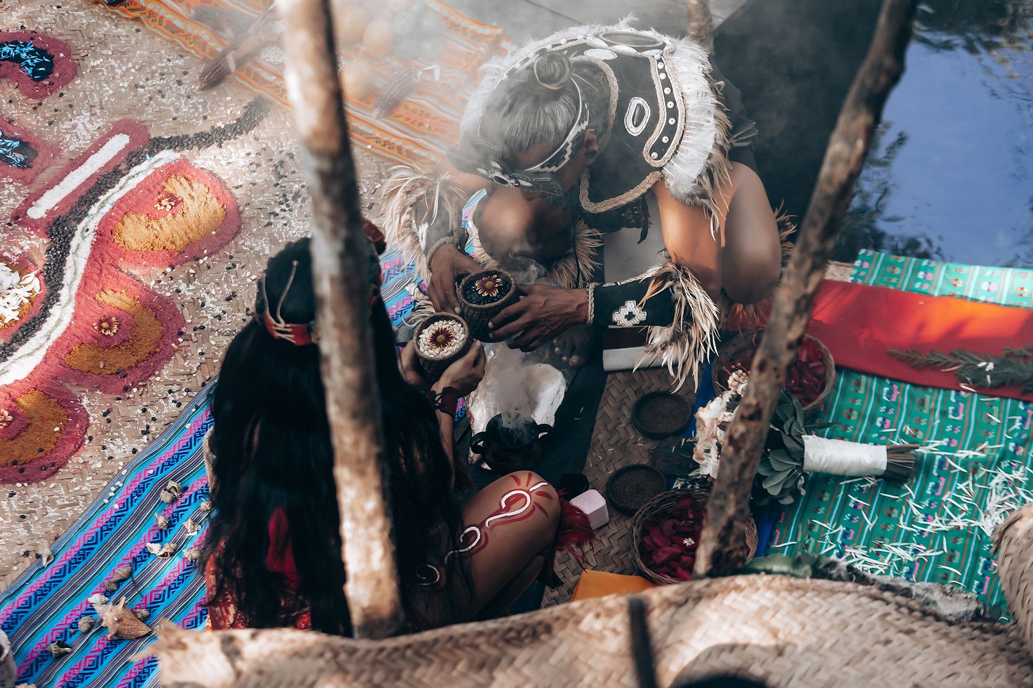 Ceremonial items and decorative textiles laid out during a traditional ritual.