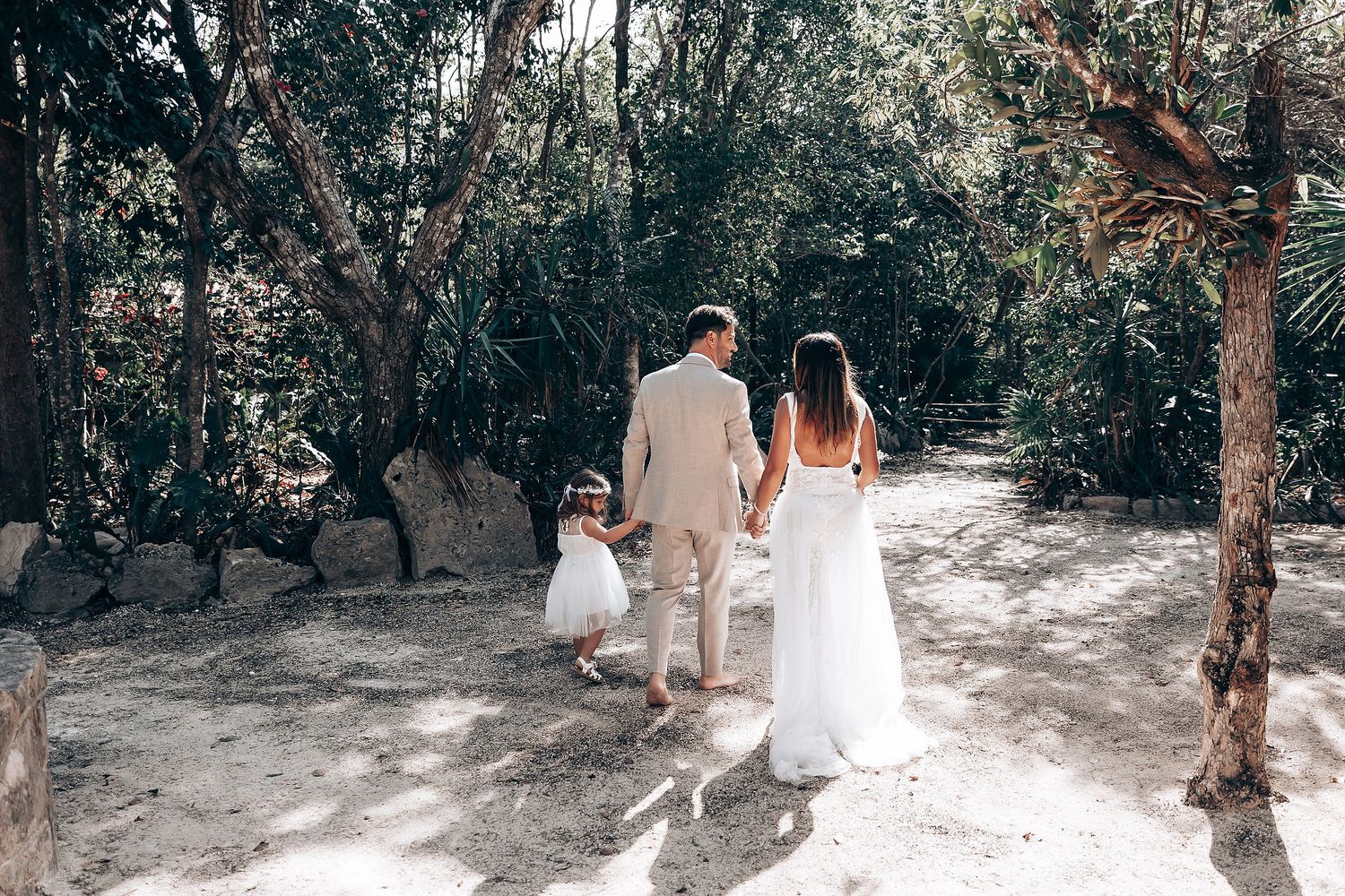 Romantic wedding moment captured in a natural garden setting with tropical foliage.