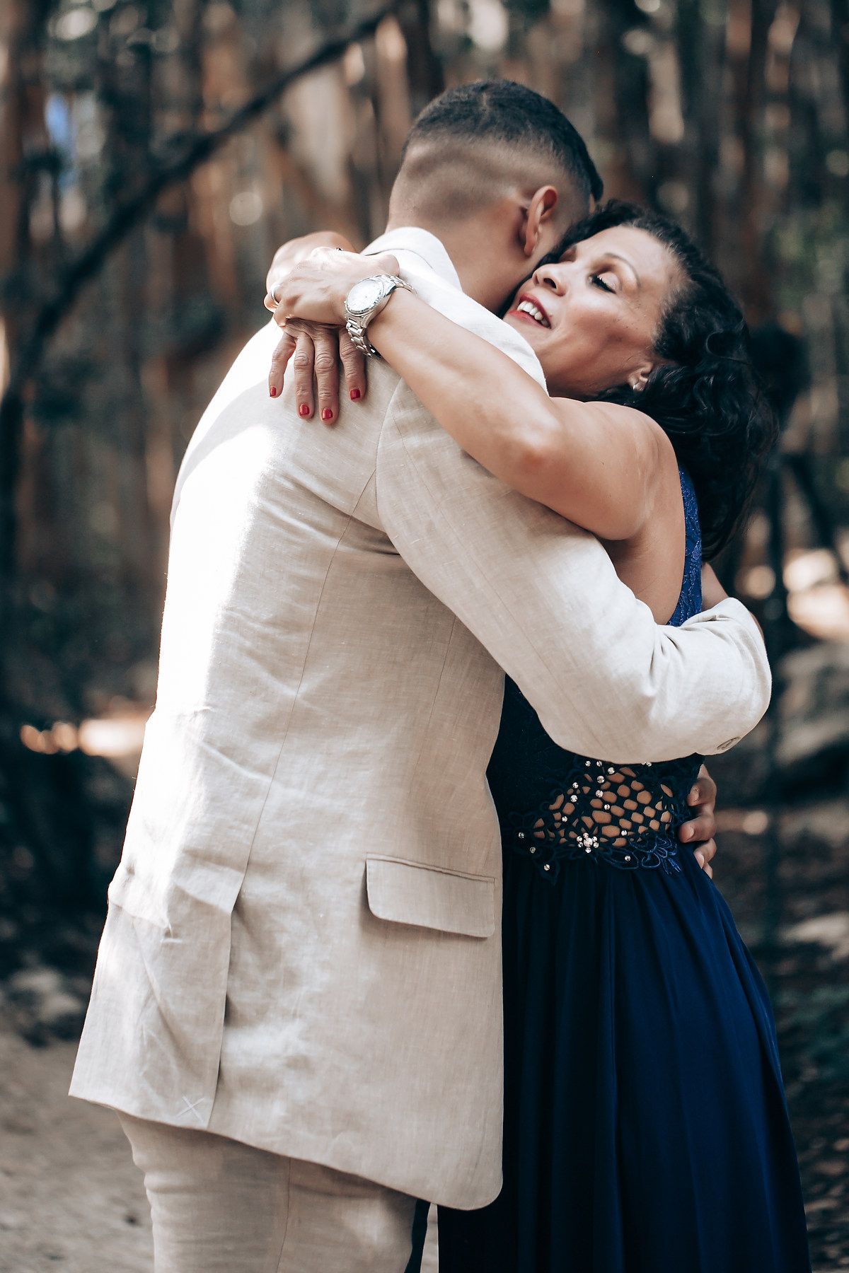 An intimate moment captured between a couple in a wooded setting with one wearing navy and one in cream.