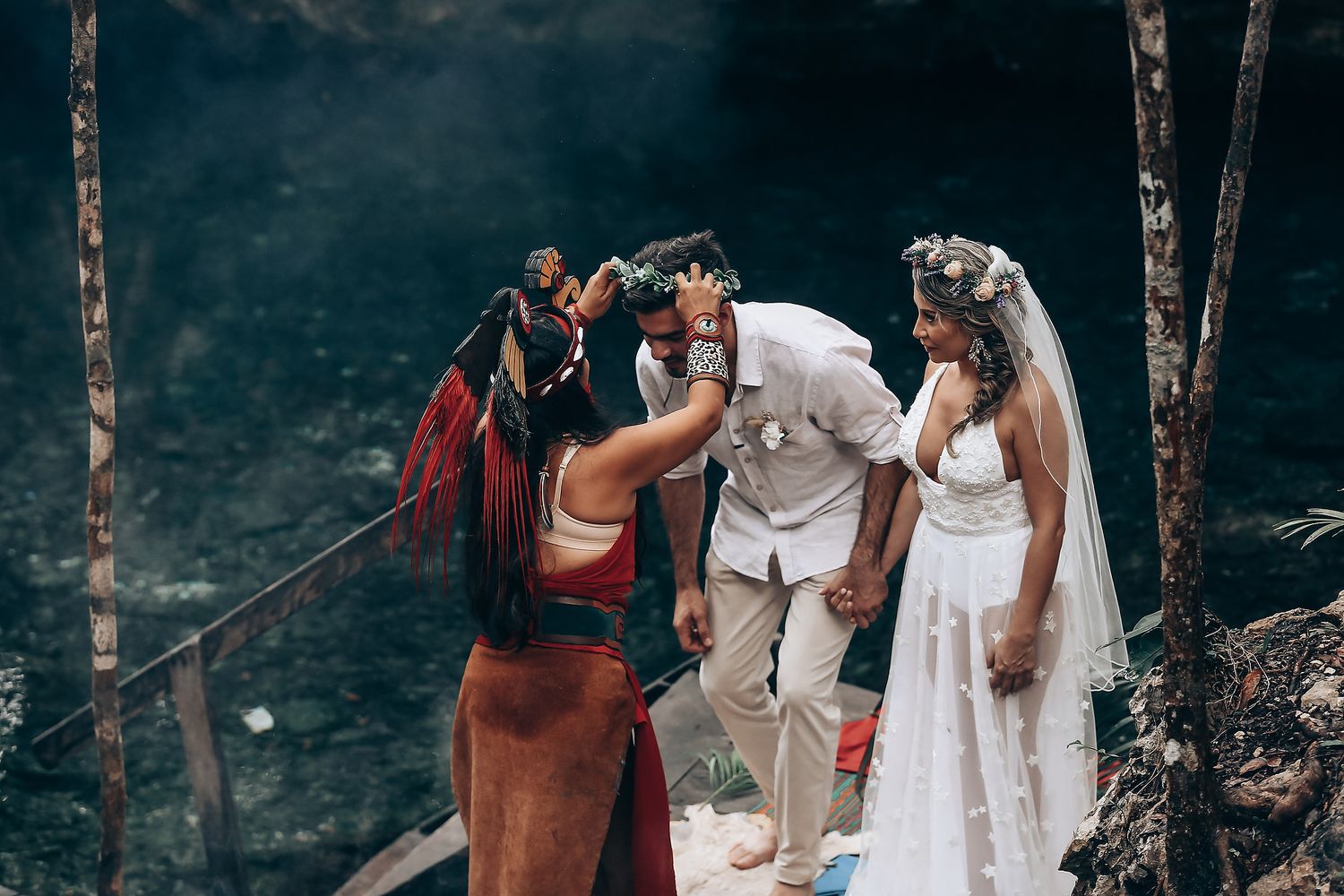 A traditional wedding ceremony takes place in a mystical forest setting with lush greenery and natural decor.