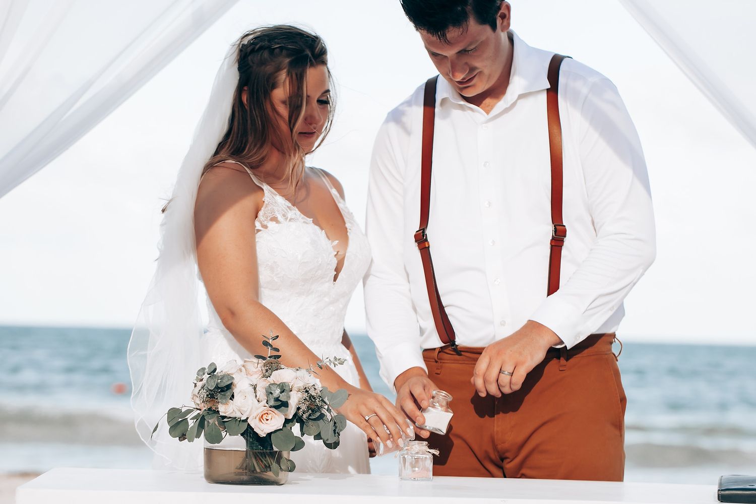 Intimate beachside wedding moments with ocean waves in the background.