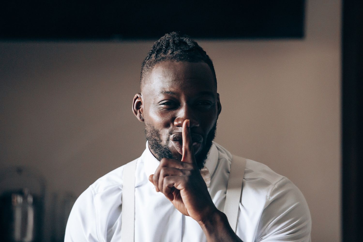 Person in white attire sitting indoors with contemplative expression.