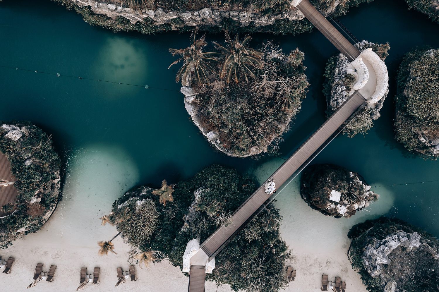 Aerial view of a tropical waterfront wedding venue with natural rock formations.