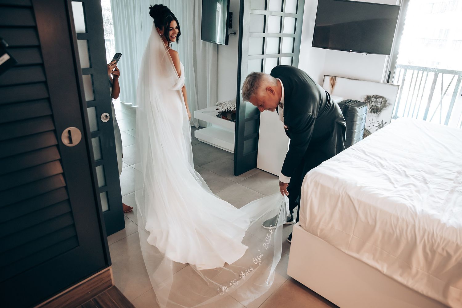 Bride in a flowing white wedding gown sitting in an elegantly lit room.