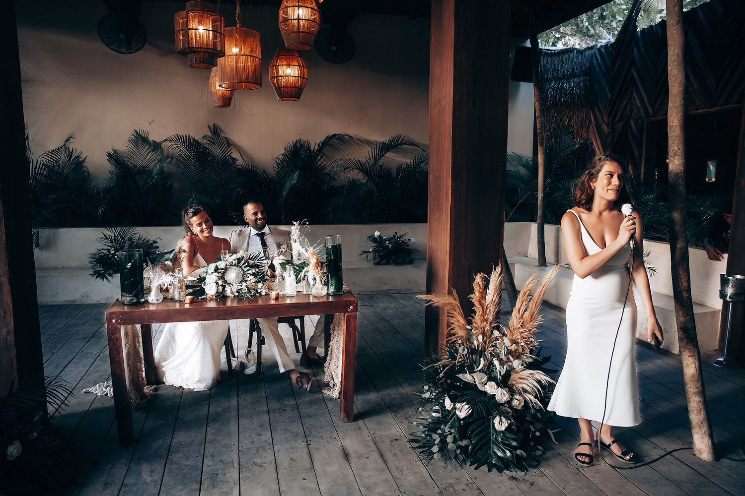 Evening reception venue with warm lantern lighting and tropical decor.