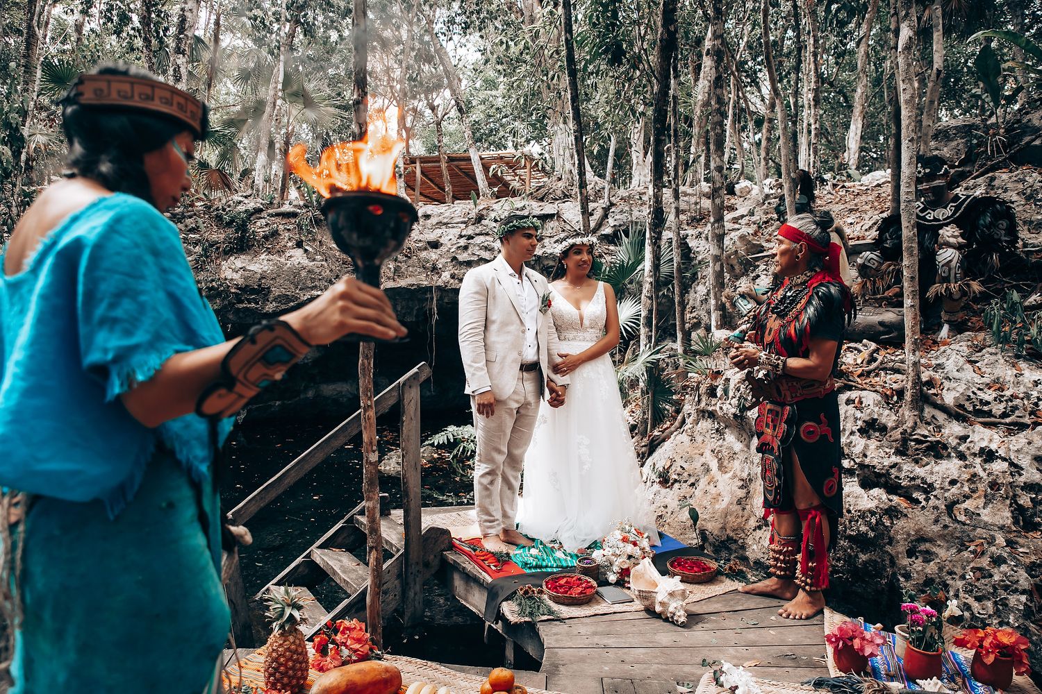 A spiritual ceremony takes place in a wooded area with torches and traditional decorations.