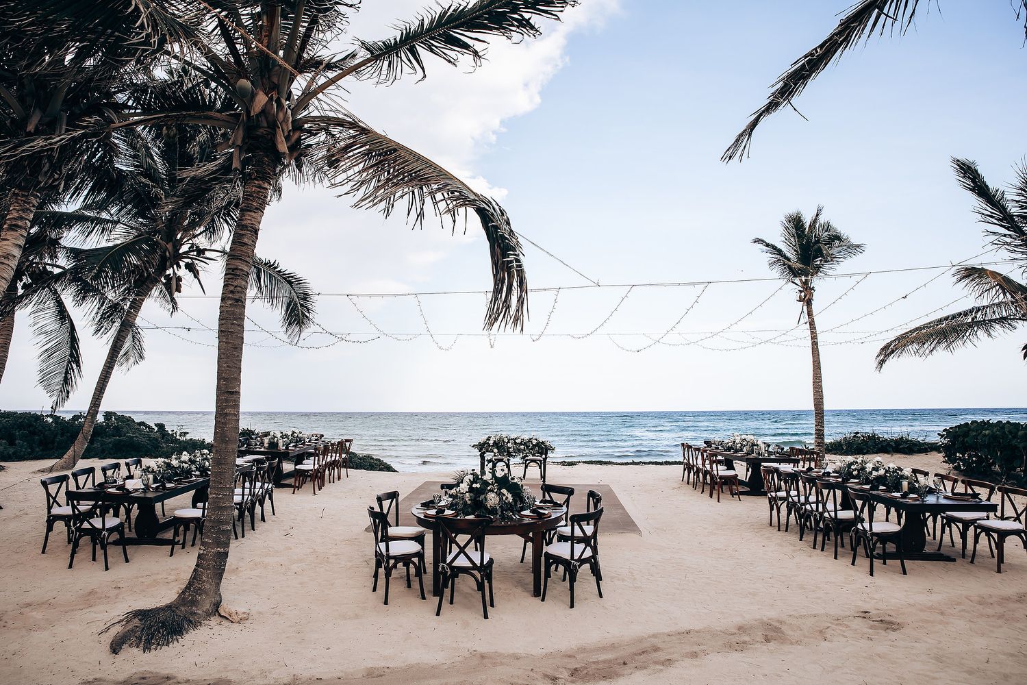 Panoramic view of a tropical beach wedding venue with palm trees and ocean views.