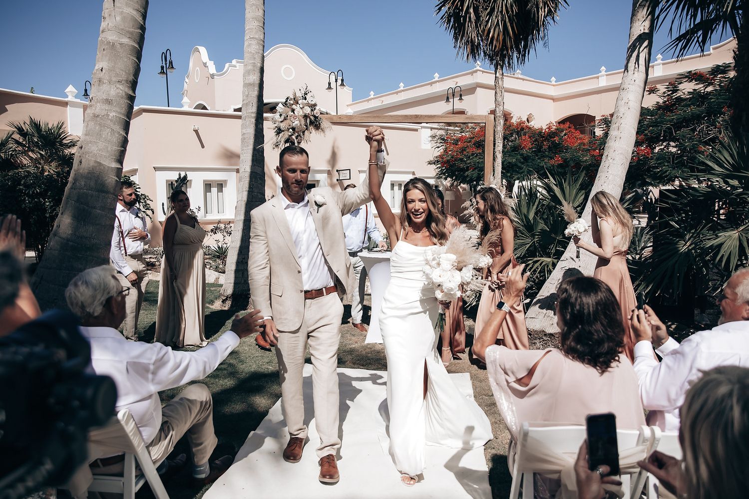 A wedding ceremony with the bride and groom surrounded by guests.