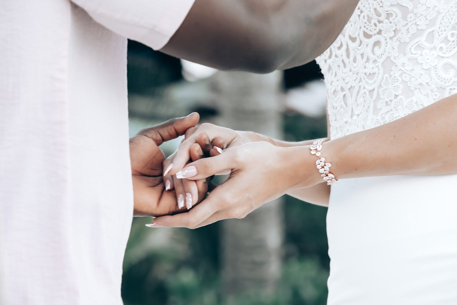 A woman in a white dress is being helped with her dress by another person.
