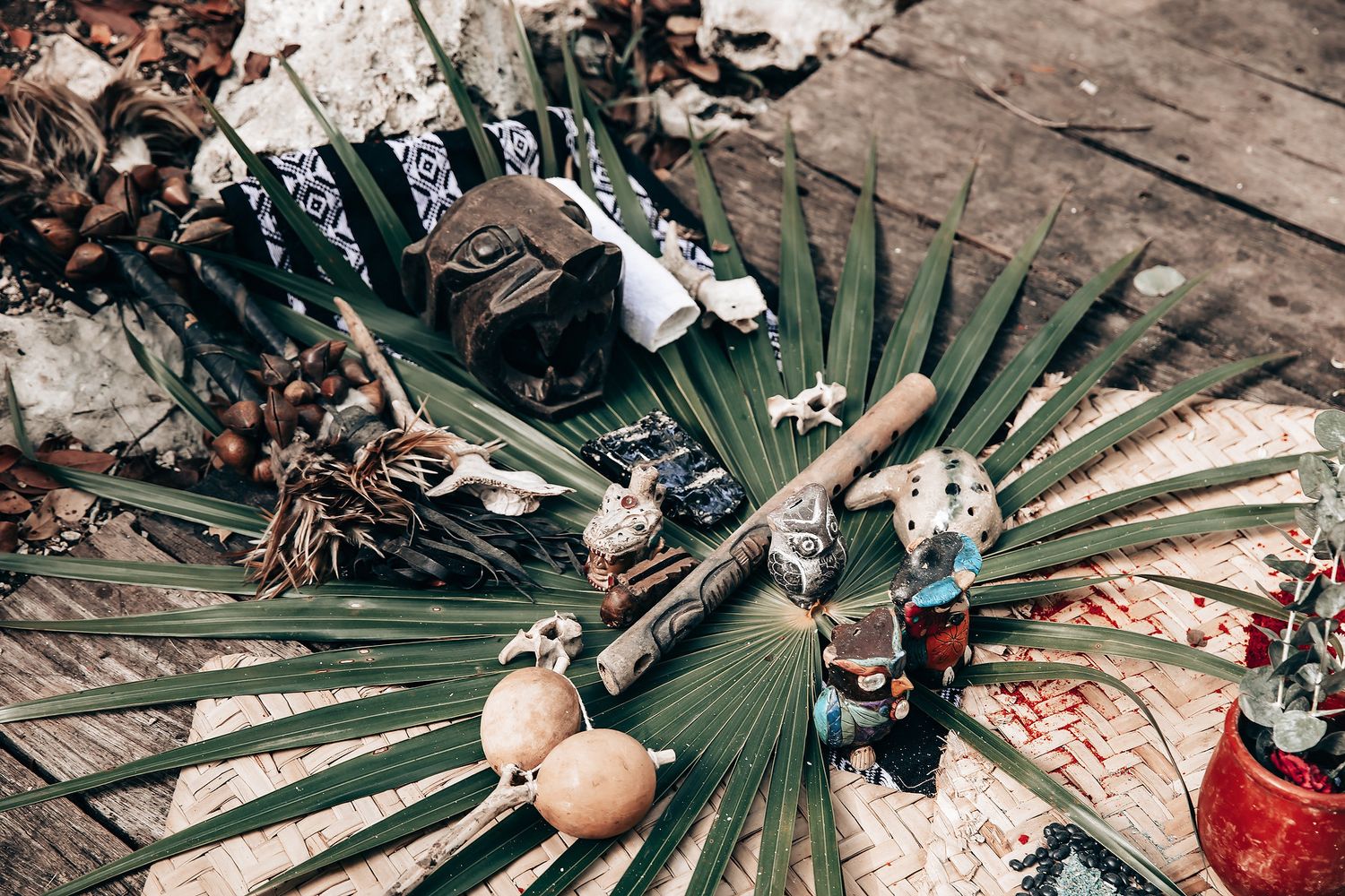 Traditional Mayan ceremony items arranged on palm fronds with decorative elements and natural materials.