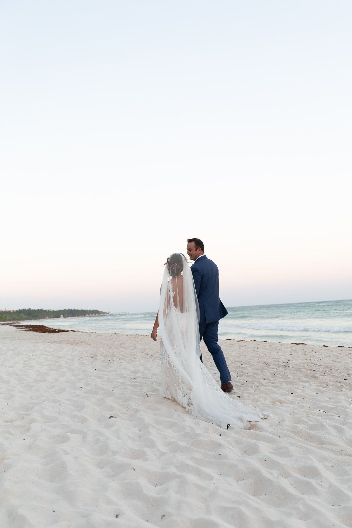 Bride and groom walking on the beach at Saasil Kantenah