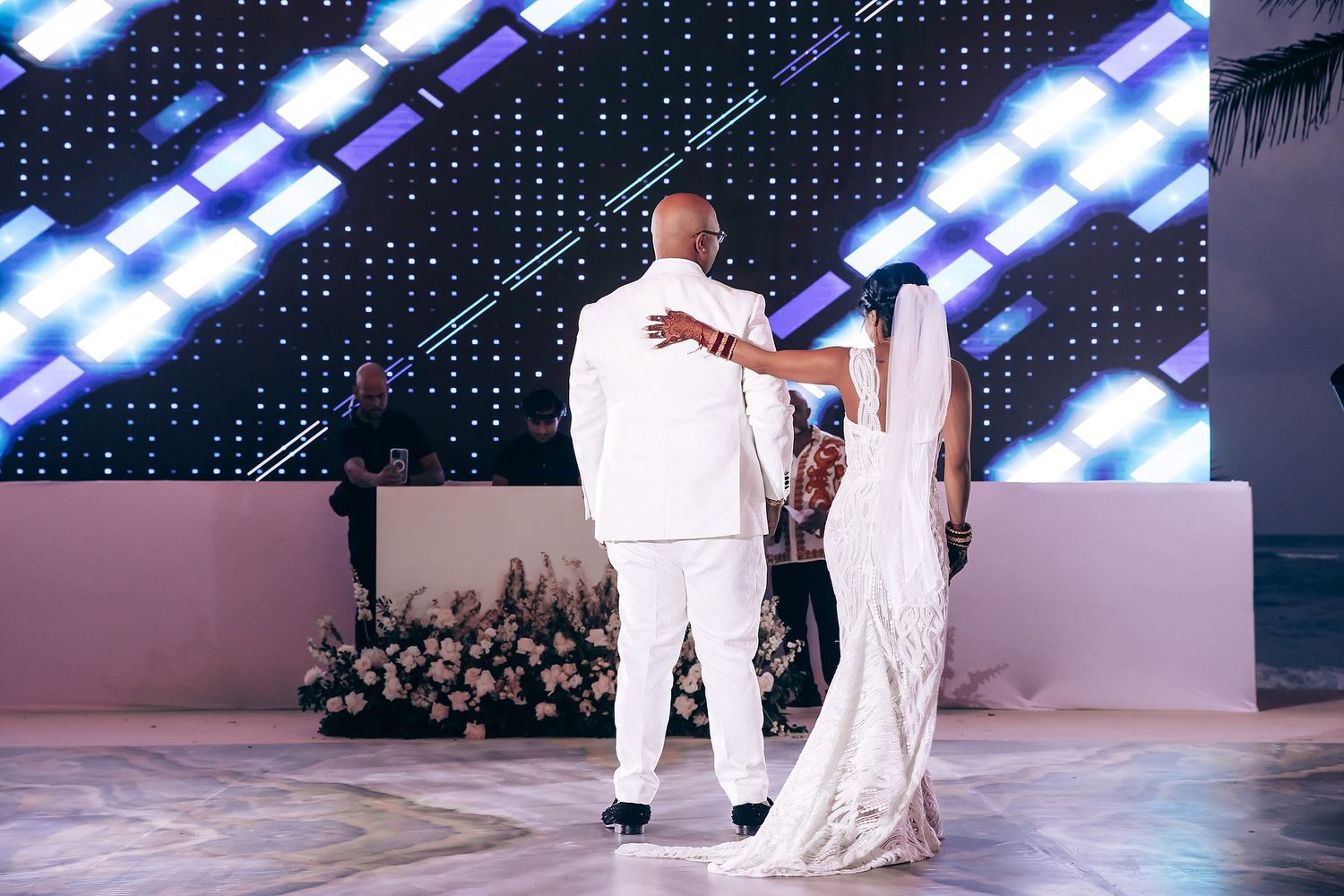 A stage performance with dramatic blue lighting and white-clad performers against a dark backdrop.