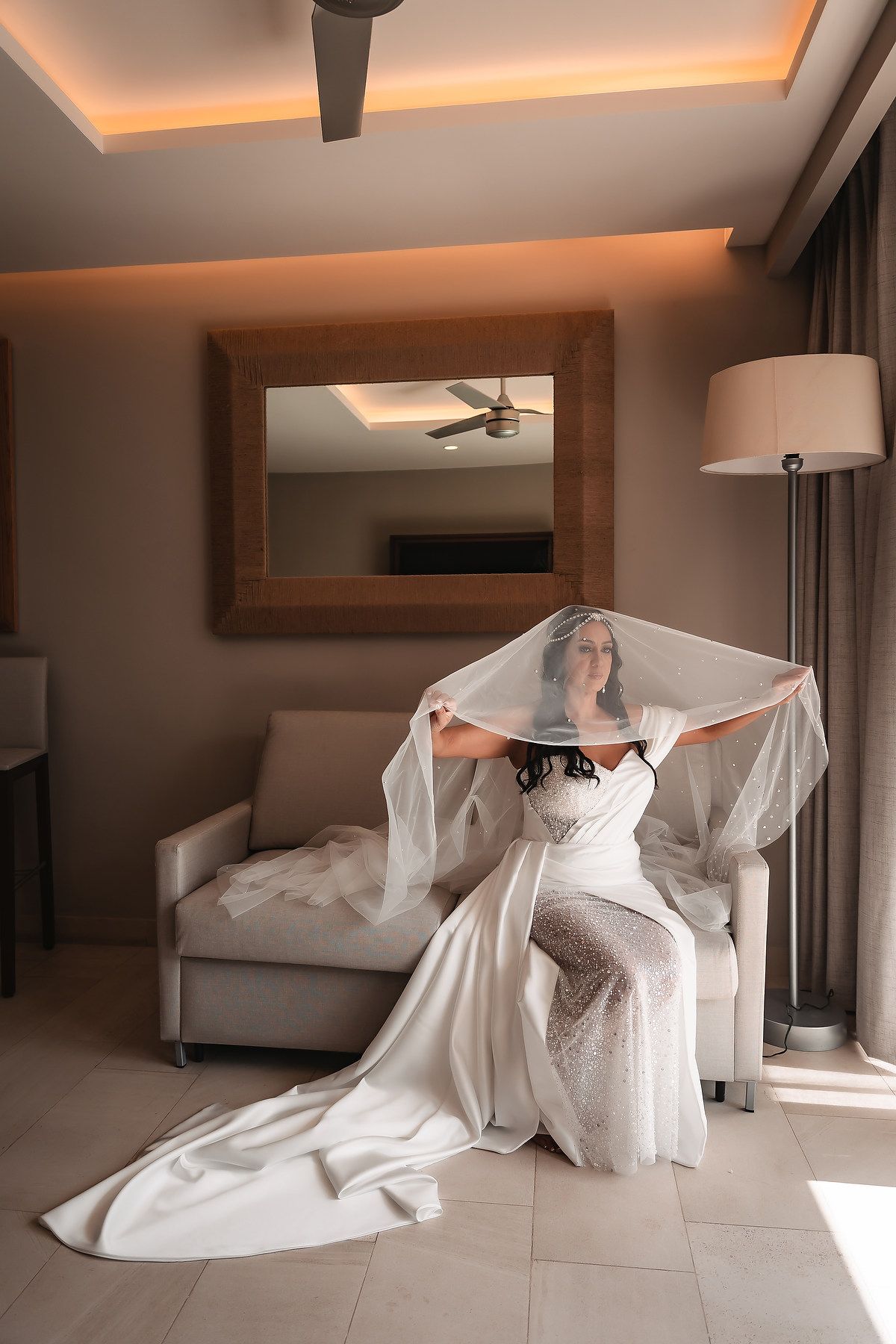 Wedding dress photography session showing flowing movement with white veil against modern interior.