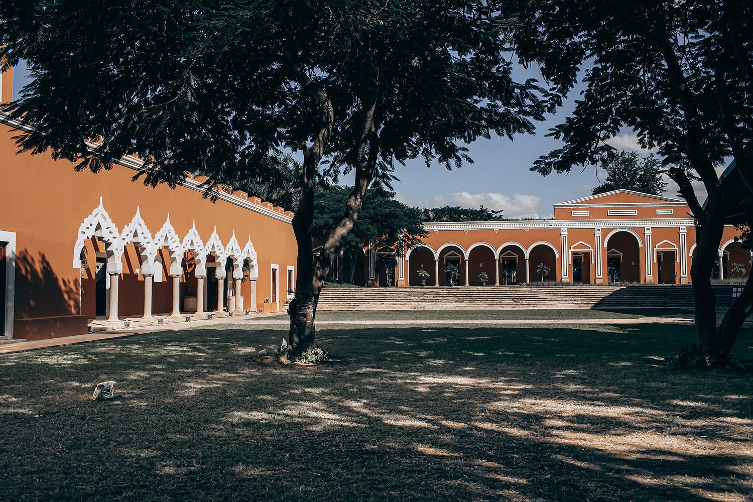 Historic hacienda buildings with arched porticos and colonial architecture stand against a clear blue sky in Mexico.