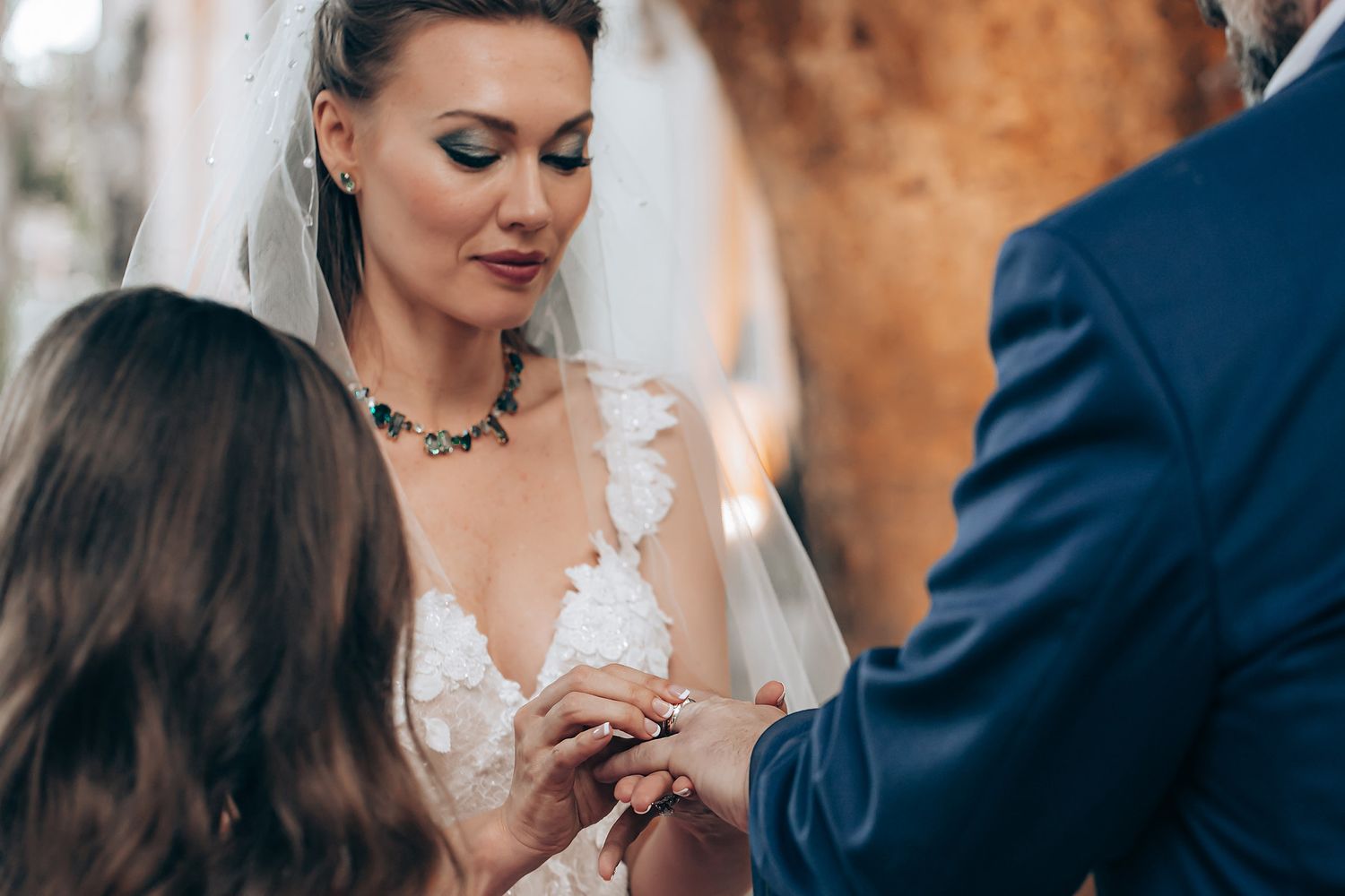 Close-up shot of a bride and groom's hands during their wedding ring exchange ceremony.