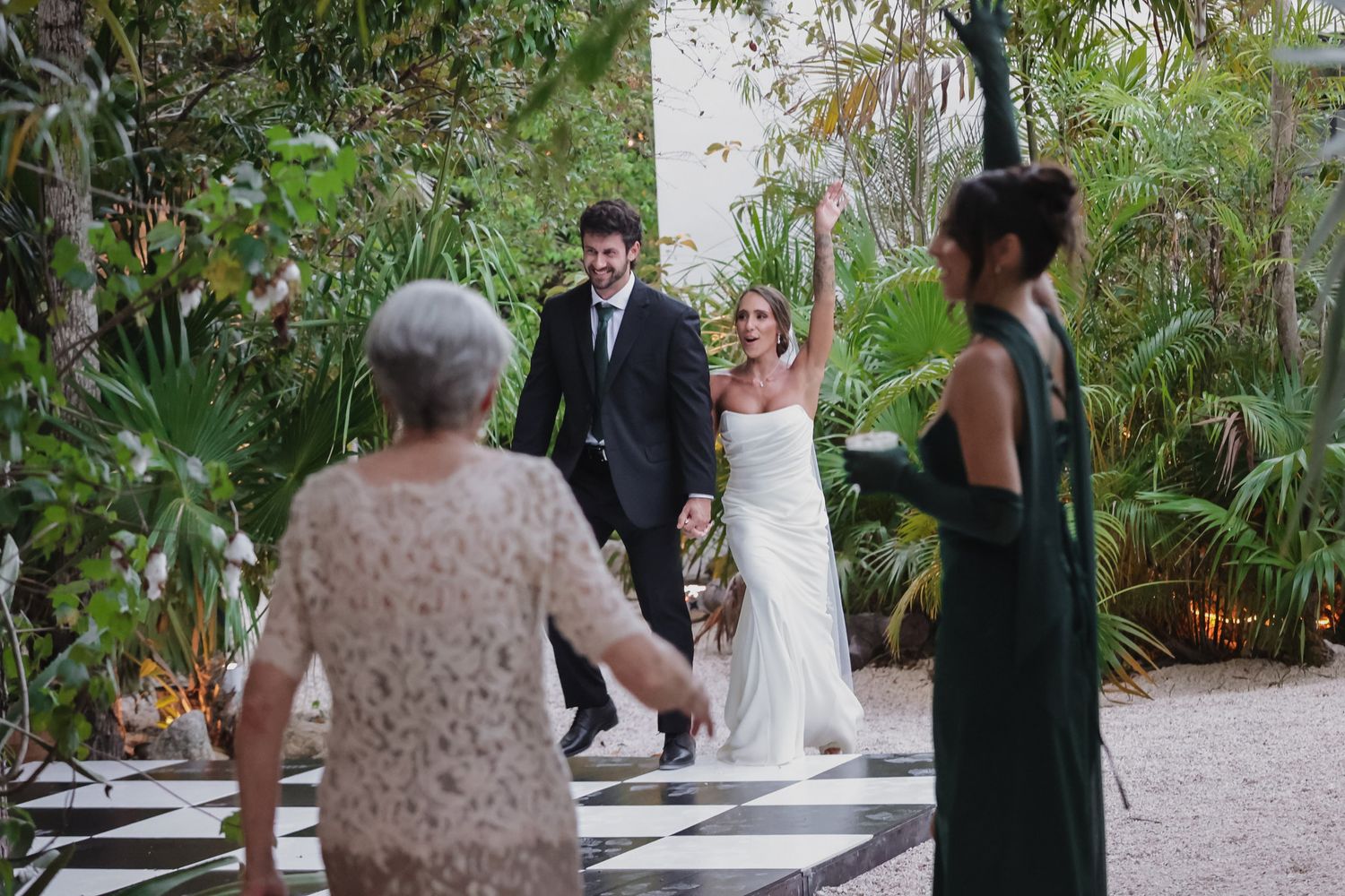 Bride and groom celebrate after wedding ceremony in lush garden venue.