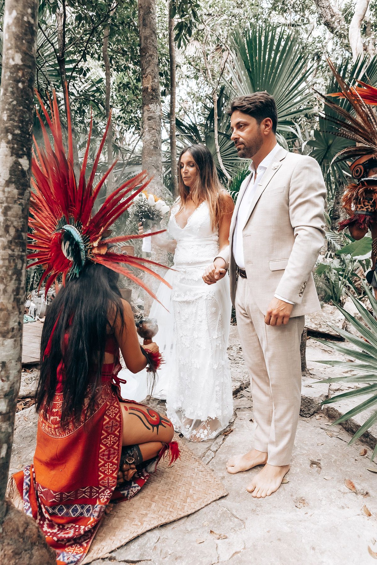 Traditional Mayan ceremony performed in a lush jungle setting with ceremonial headdresses and white attire.