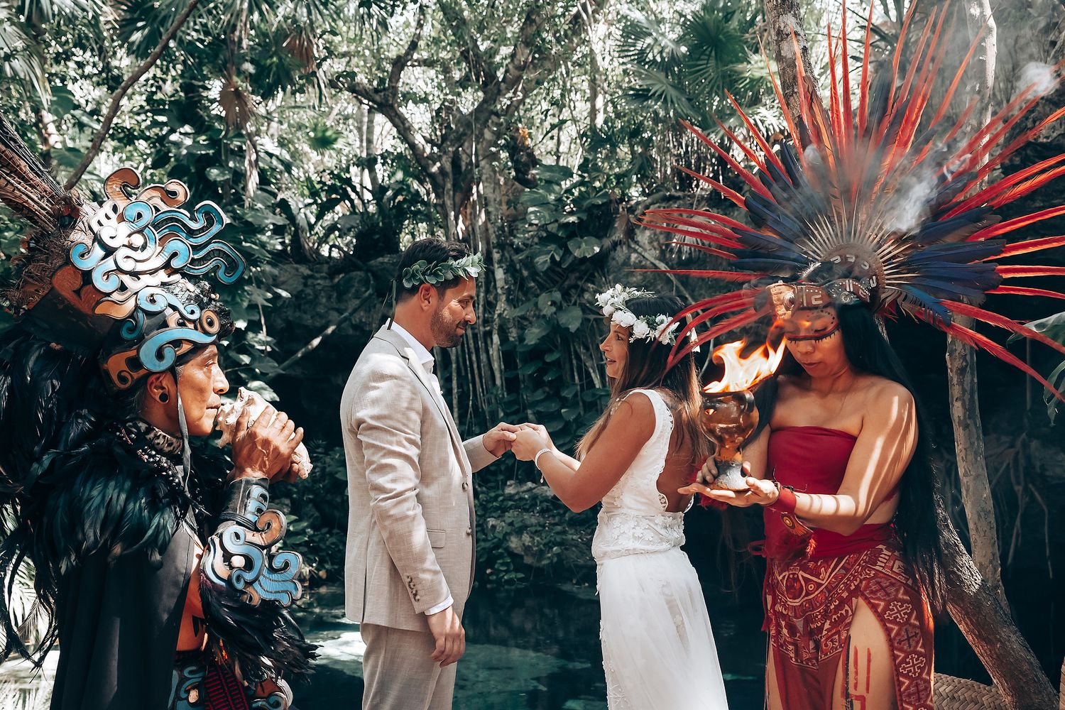 Wedding guests gather in a tropical garden setting with traditional decorative elements and natural lighting.