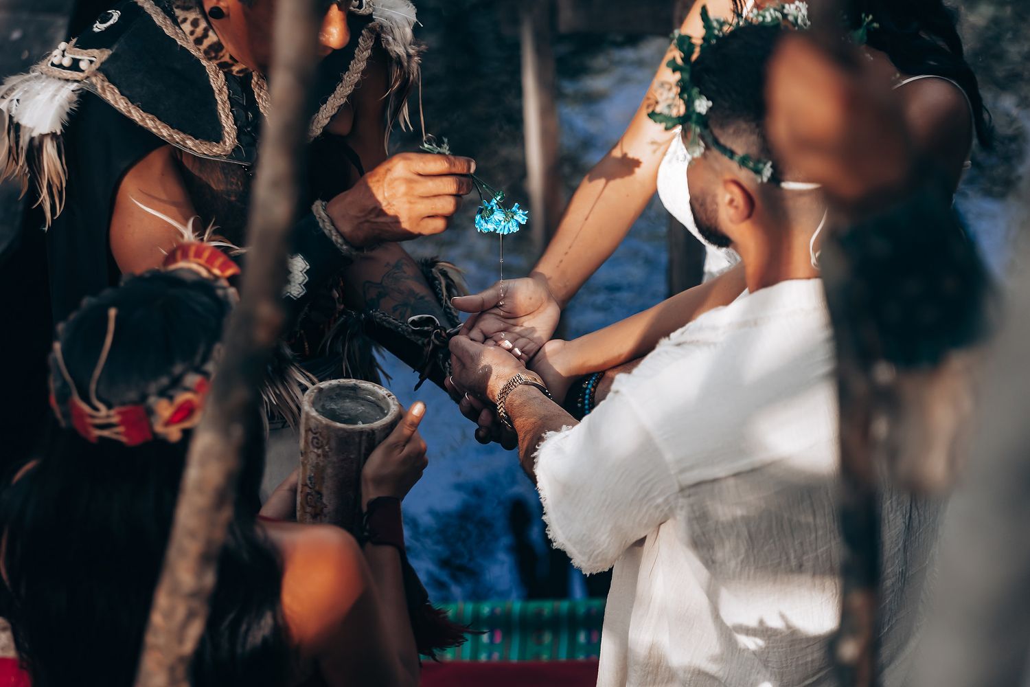 Guests dance and celebrate at an outdoor wedding reception surrounded by trees.