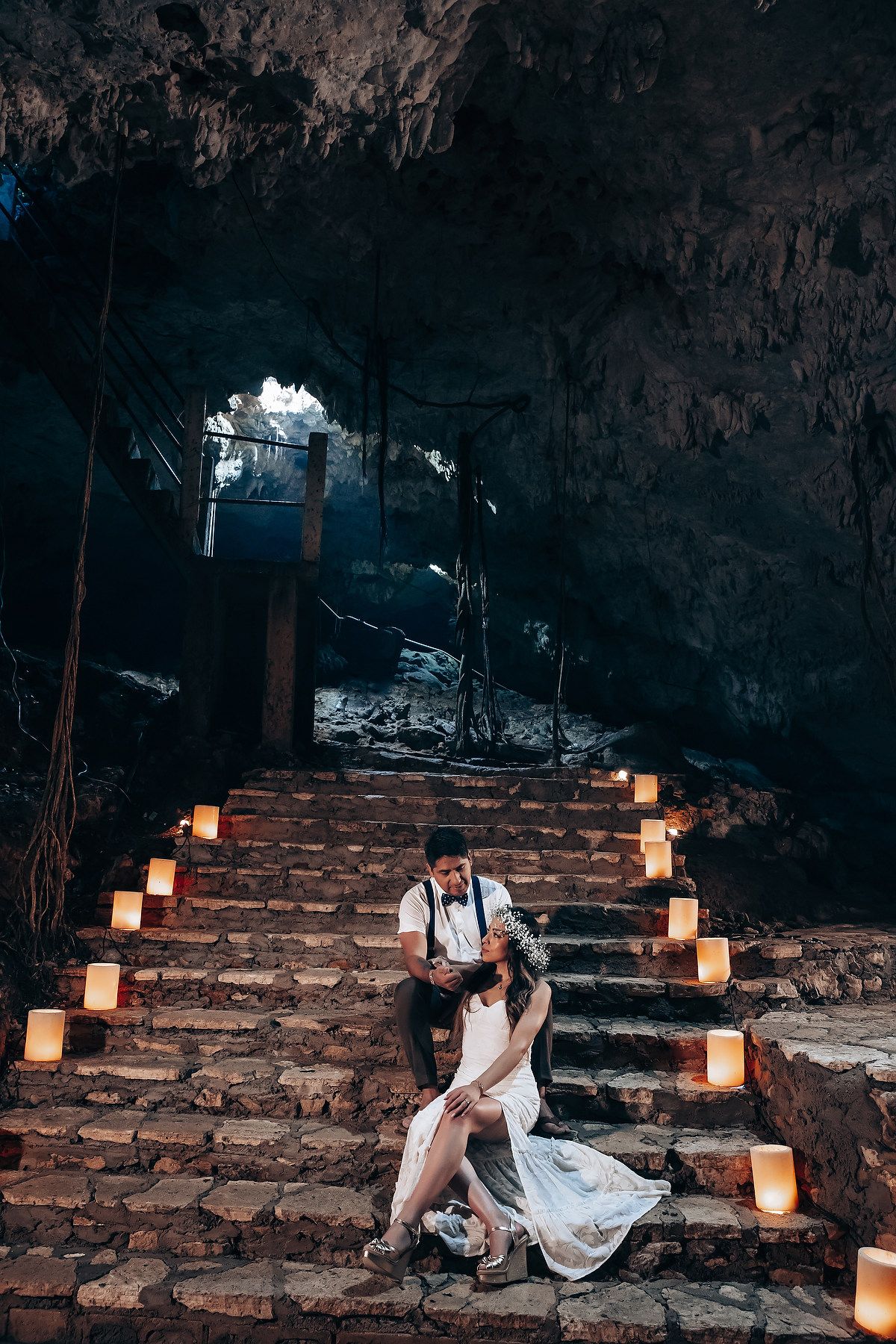 A dimly lit stone staircase adorned with glowing lanterns creates a romantic atmosphere in an ancient setting.