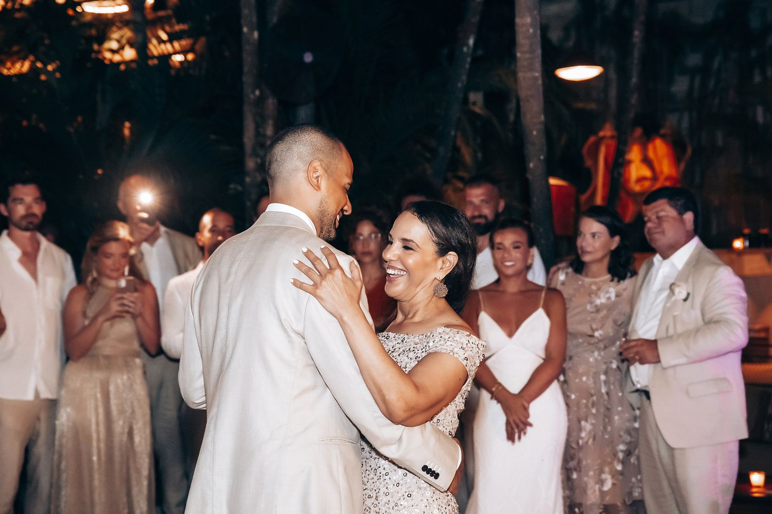 Wedding reception dance party at night with festive lighting and guests celebrating on the dance floor.