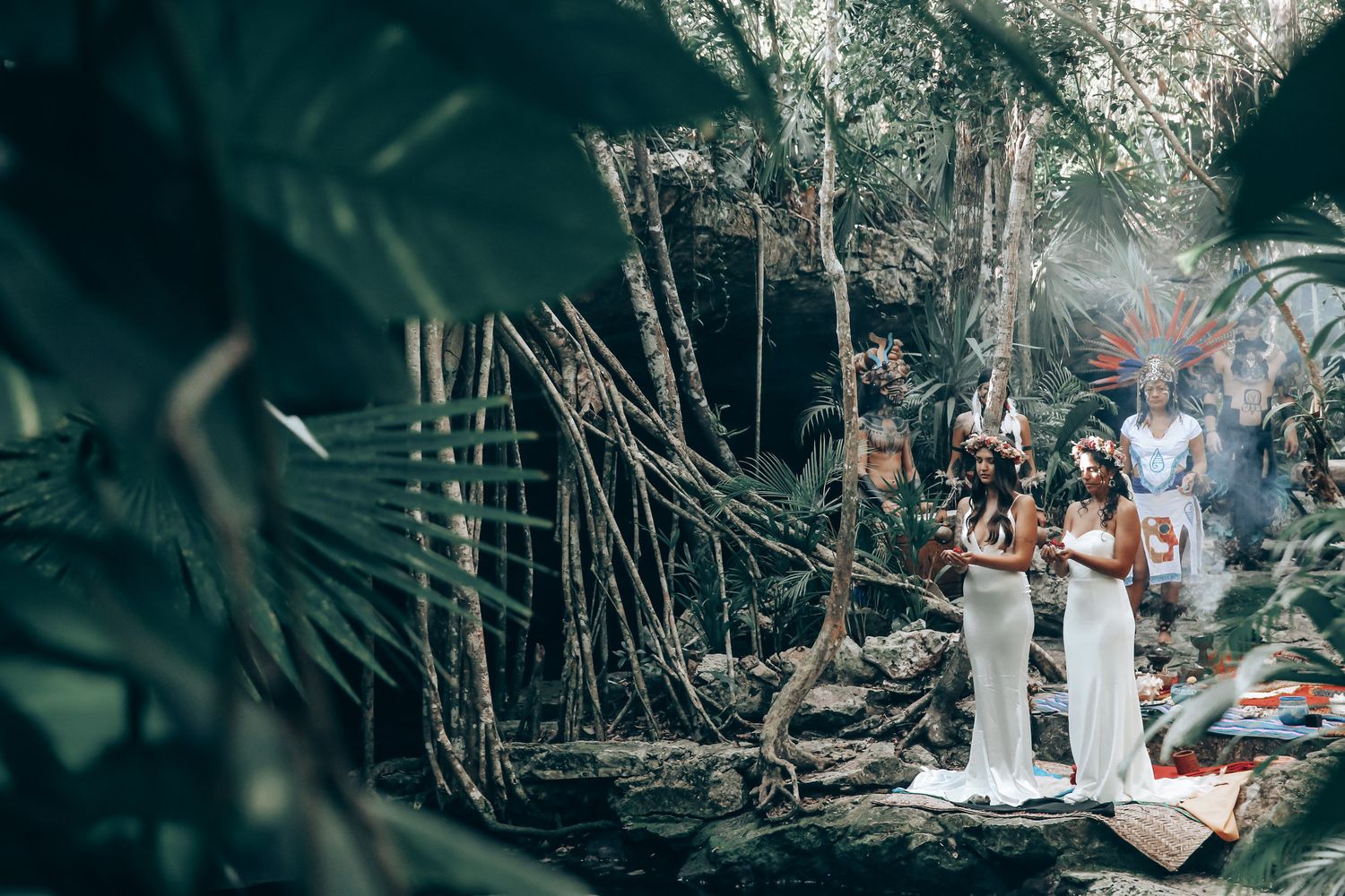 An intimate forest wedding ceremony with natural decor and guests seated on wooden benches.