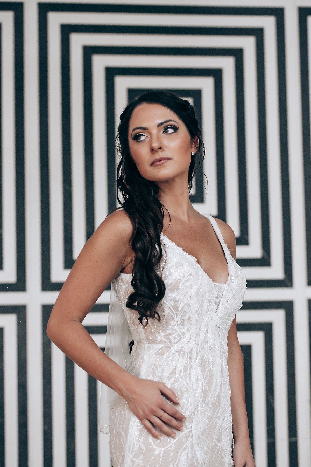 Stunning bridal portrait against geometric black and white striped wall backdrop.