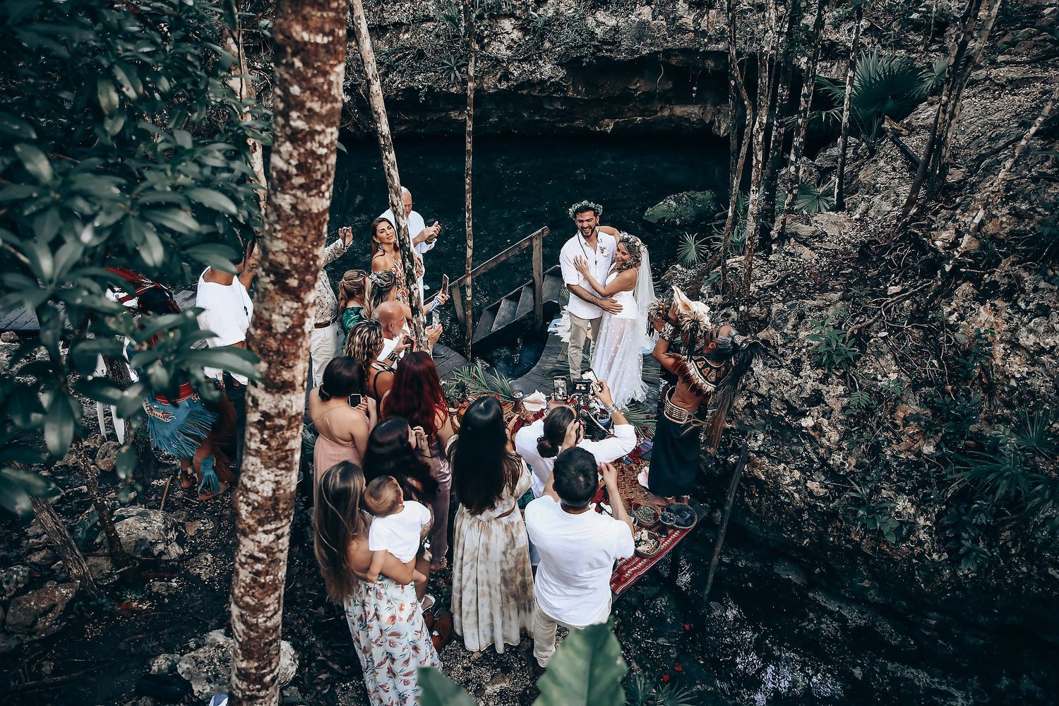 Forest wedding ceremony with guests gathered in a natural woodland setting.