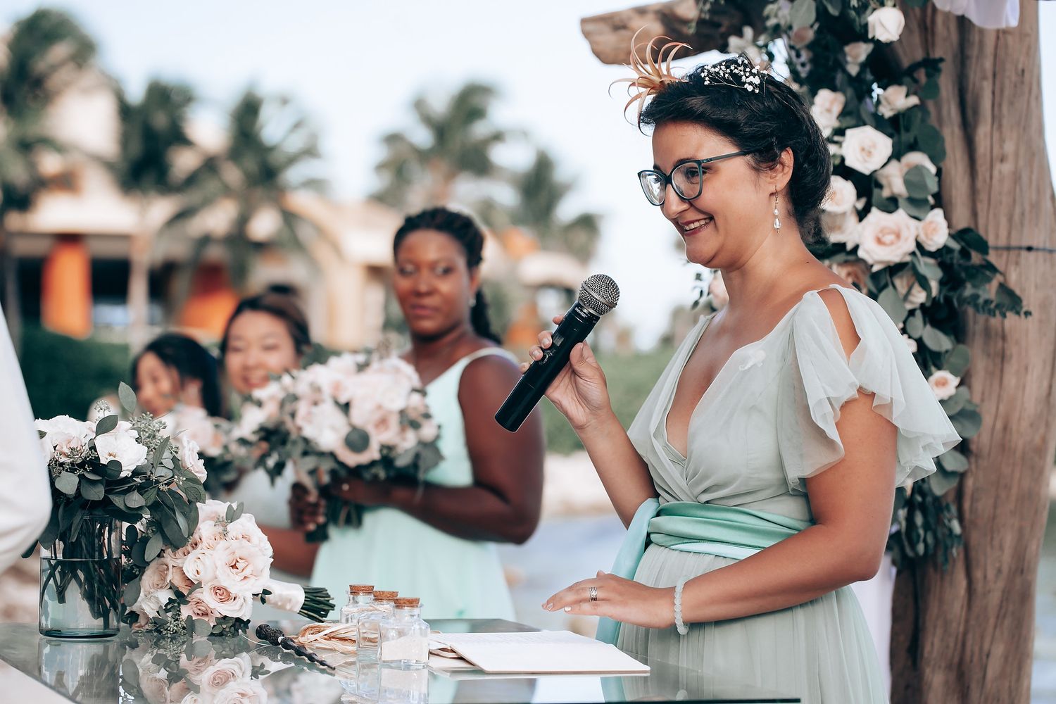 Wedding guests enjoying outdoor celebration with floral decorations and palm trees.