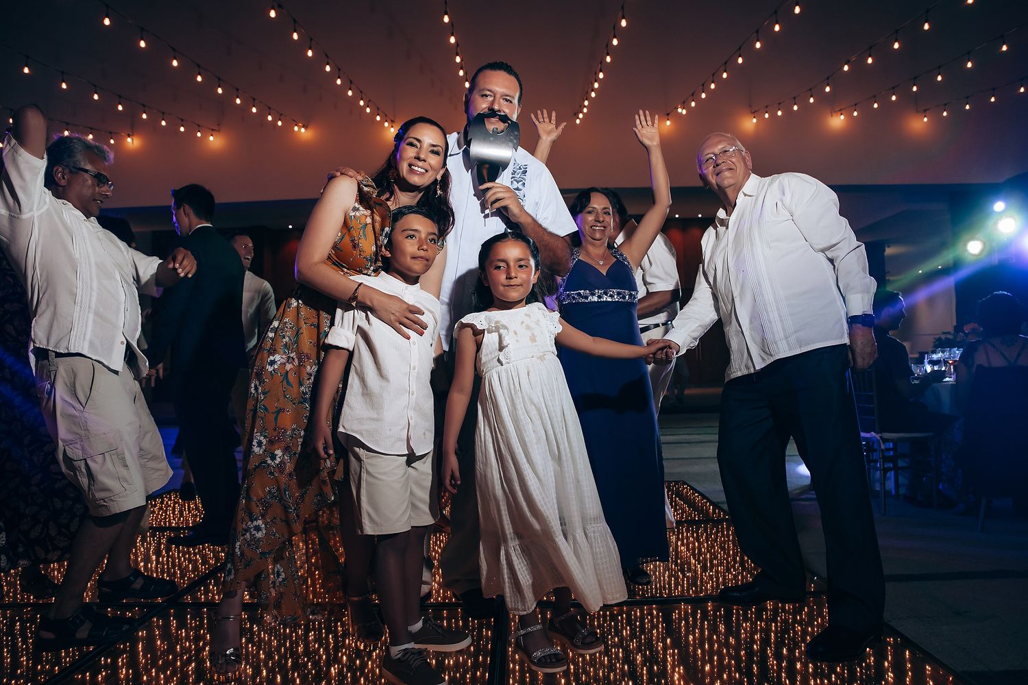 Wedding reception dance party with string lights creating a festive atmosphere.