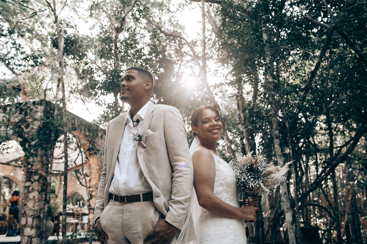 Wedding ceremony guests gathered in a natural wooded setting.
