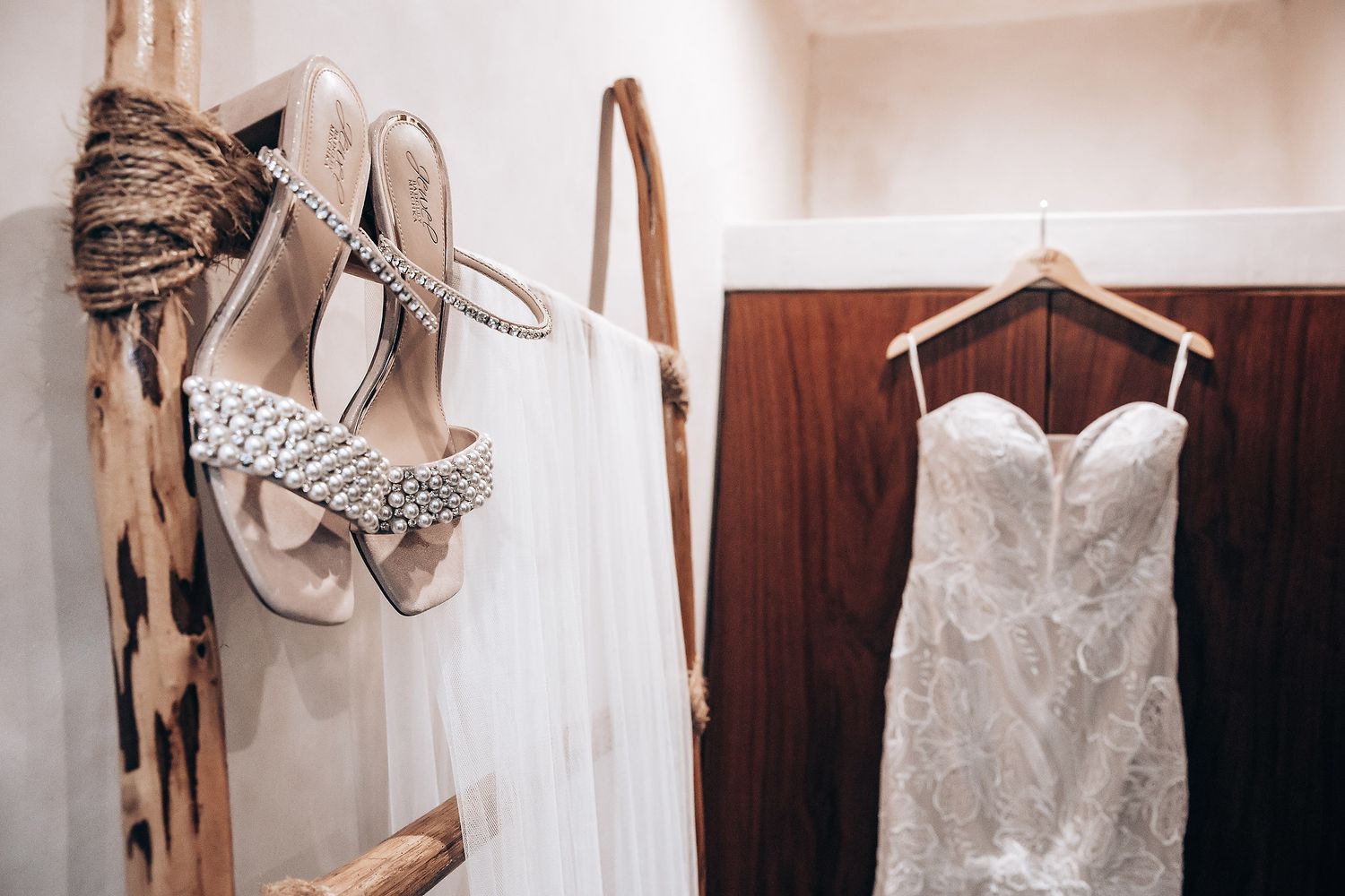 A collection of elegant white wedding dresses hanging on display showcasing intricate lace and beaded details.