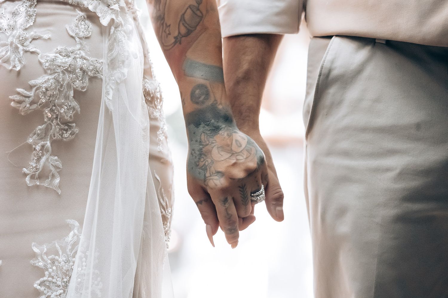 Detail shot of white lace wedding dress and formal attire during ceremony.