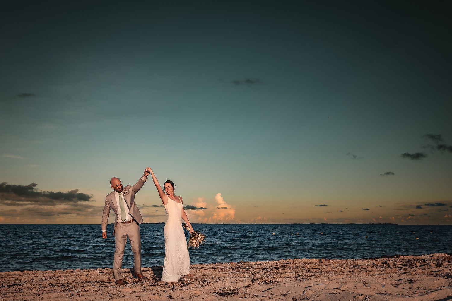 Bride and groom walking on the beach at TRS Coral Costa Mujeres