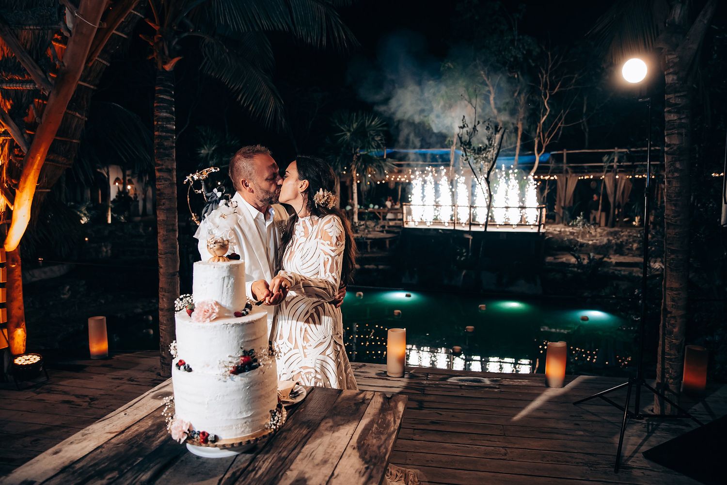 Outdoor evening wedding reception with atmospheric lighting and dancing under the stars.